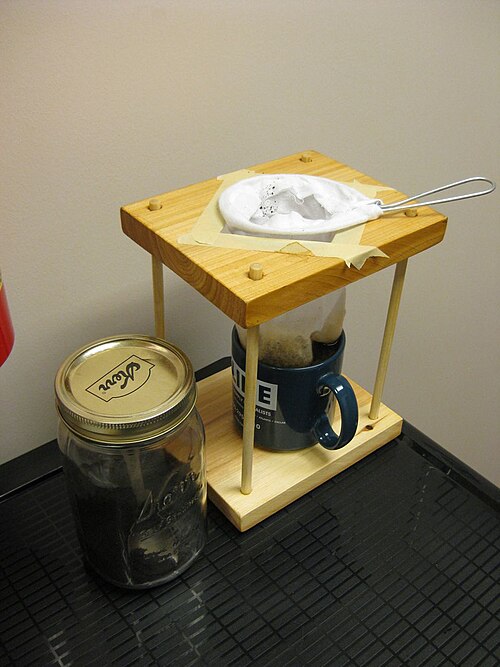 Wooden stand with cloth filter sock over mug